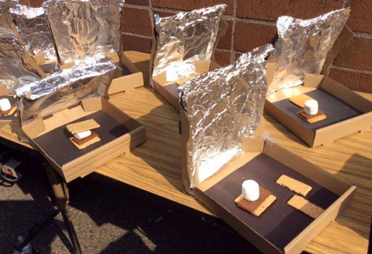 Making amores in the sunshine using tin foil to melt the chocolate and marshmallows.